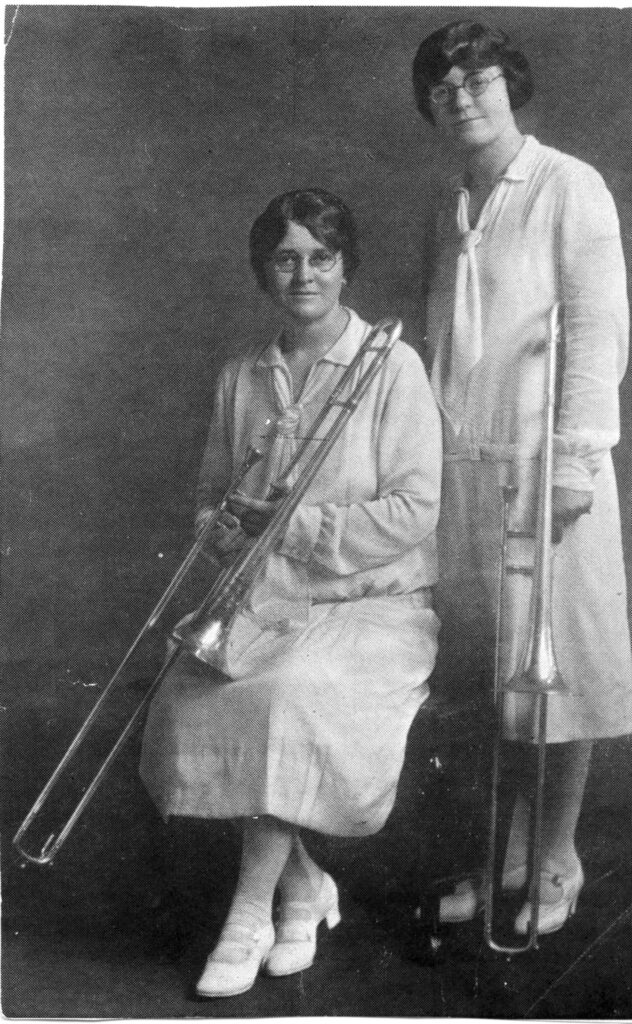 Sisters Beulah Argue (standing) and Zelma Argue (sitting) with their trombones.